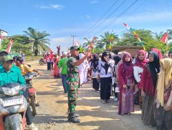 Serda Sugianto, Anggota Satgas TMMD ke-125 Kodim 0321/Rohil Wujudkan Kebersamaan melalui Pengamanan Karnaval HUT ke-80 RI di Rokan Baru